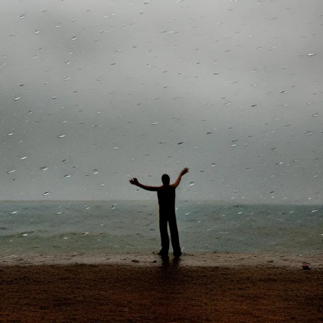 a golden rain at the Caspian sea, a man standing with open arms under the rain 