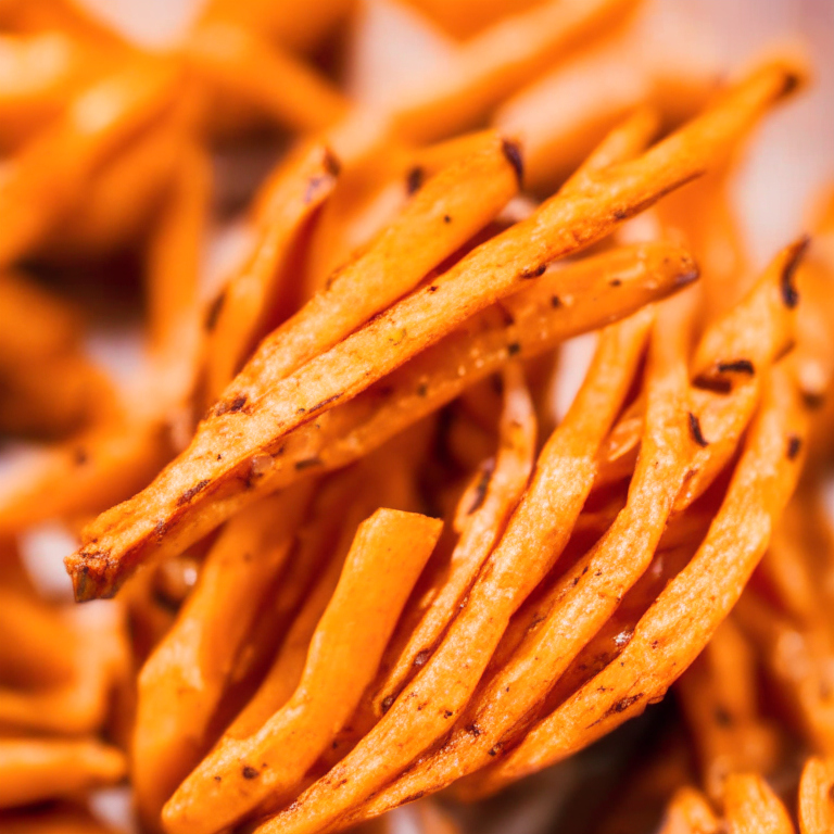 A close-up photo of Oven-Baked Sweet Potato Fries filling most of the frame, taken with bright, clear studio lighting and a lens that provides razor-sharp focus so every nook and cranny of the sweet potato fries are completely in focus with no blurry areas