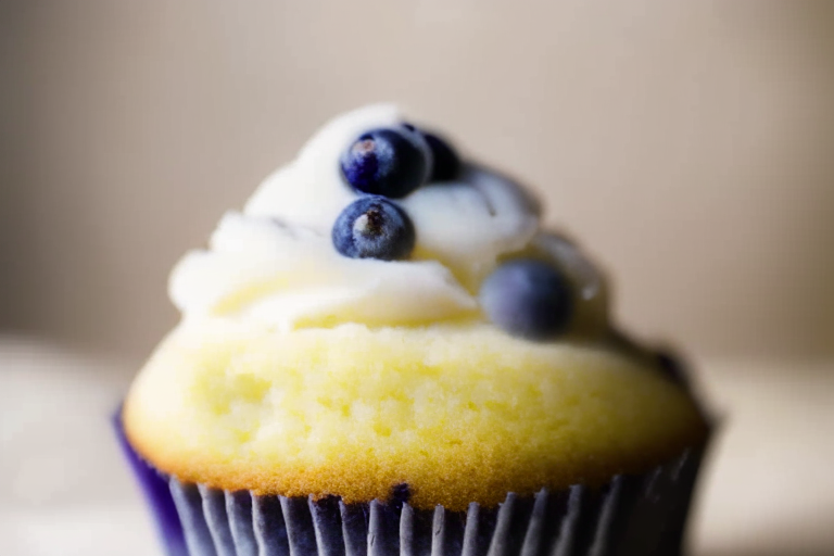 A close-up of a gluten-free lemon blueberry cupcake under bright, clear studio lighting, filling the frame and in razor-sharp focus on the frosting and crumb texture