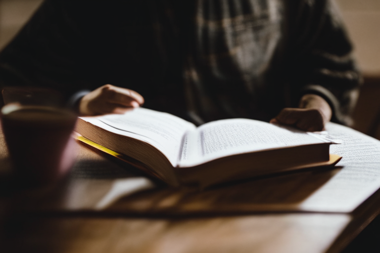 A person studying the Bible sitting at the table