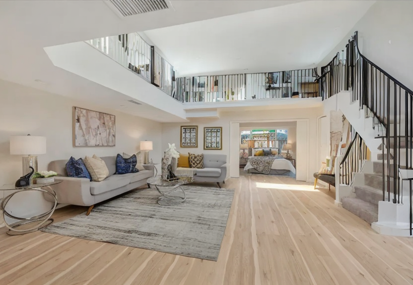 a living room filled with furniture and a staircase with a modern black metal railing