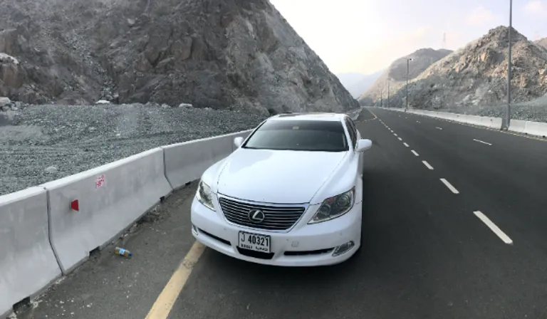 a white car is parked on the side of the road