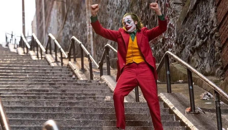 a man in a red suit and yellow shirt is standing on a set of stairs