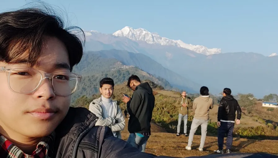 a man taking a selfie with a group of people in the background