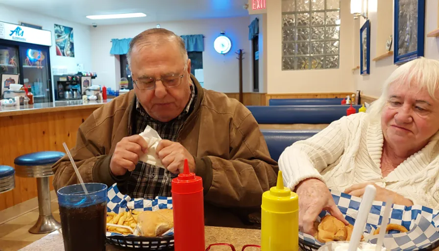 a man and woman sitting at a table eating food