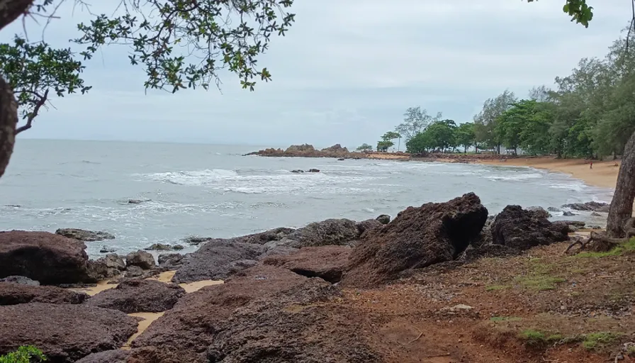 a rocky beach with a body of water in the distance