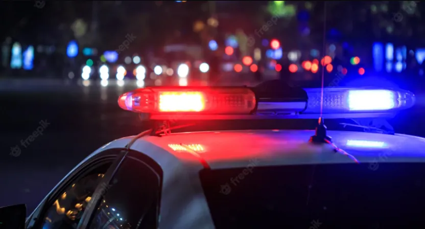 a police car with its lights on at night. blue and red lights rotating