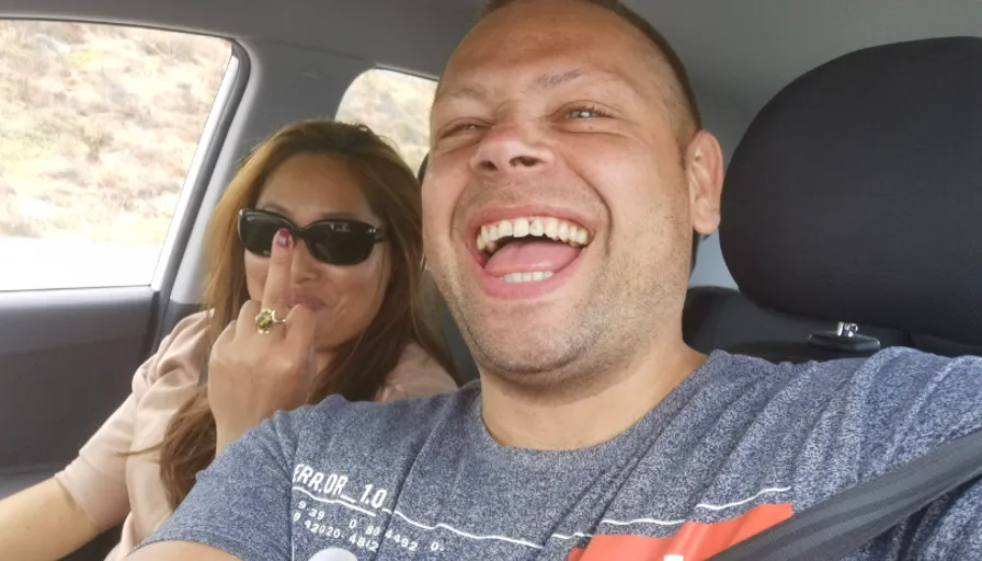 a man and woman sitting in the back seat of a car