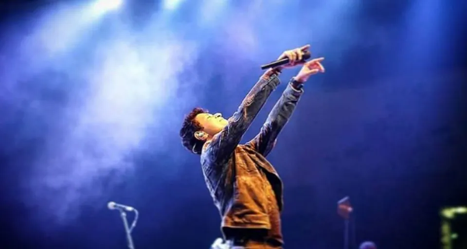 a man standing on a stage holding a microphone