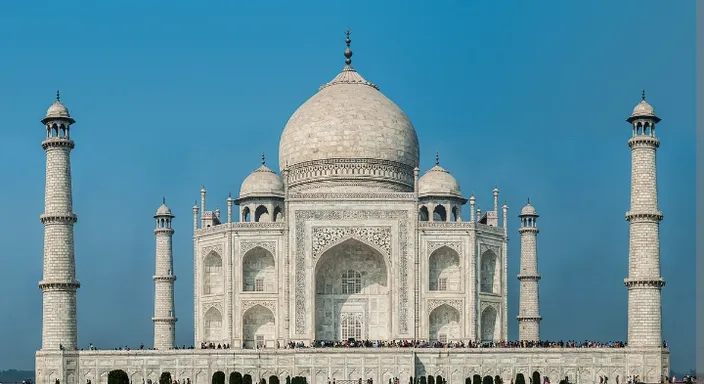 a large white building with two towers and a sky background