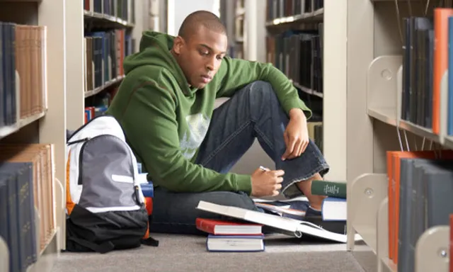 a man sitting on the floor in a library