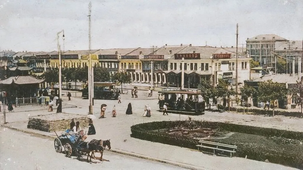 an old photo of a town square with a horse drawn carriage