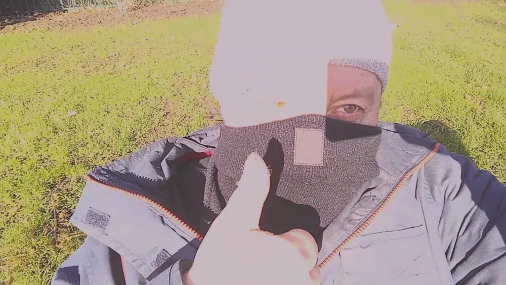 a man with a beanie on sitting in the grass