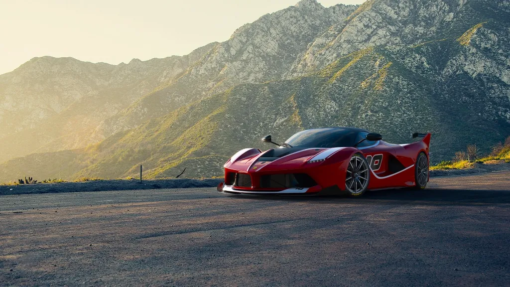 a red sports car parked in front of a mountain