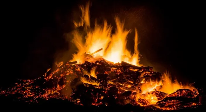 a fire blazing in the dark with lots of flames