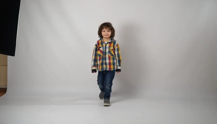 a young boy is standing in front of a white background