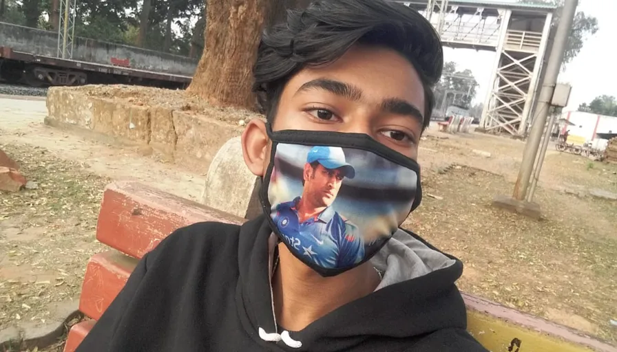 a man wearing a face mask with a picture of a cricket player