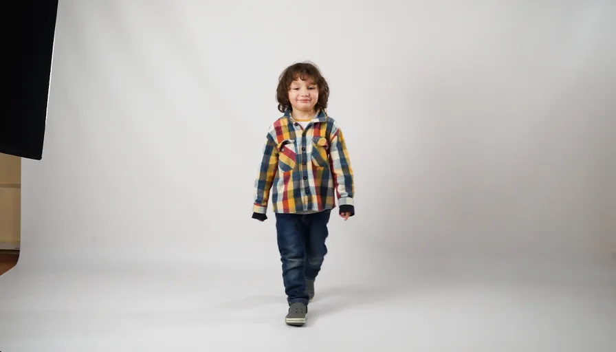 a little boy is standing in front of a white background