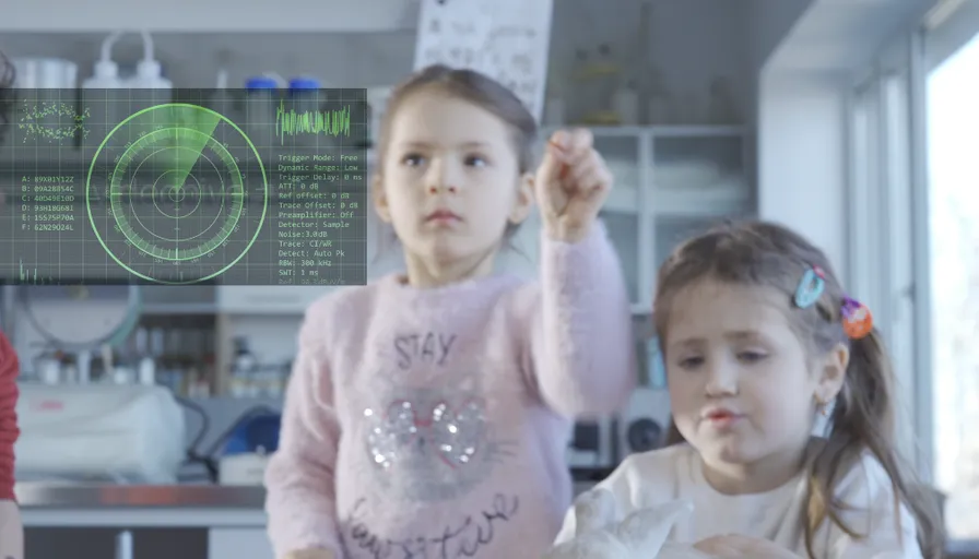 a group of children are standing in front of a computer screen