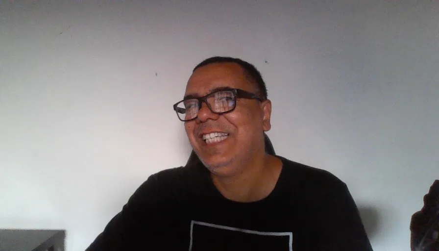 a man with glasses is smiling for the camera