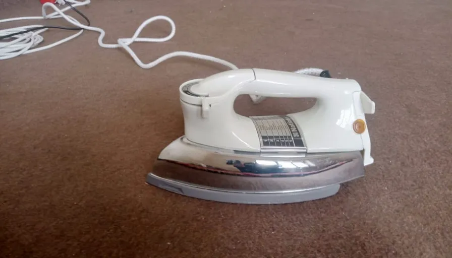 a white iron sitting on top of a brown carpet