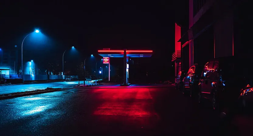 a gas station at night with red and blue lights