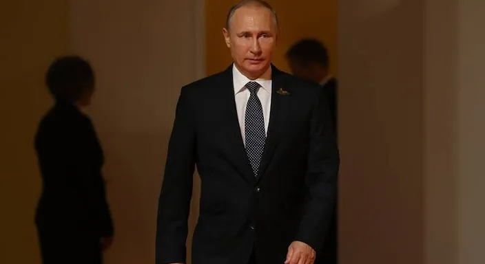 a man in a suit and tie walking down a hallway