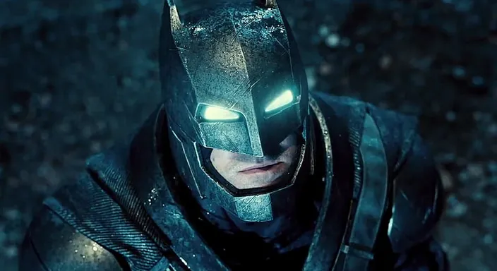 a man in a batman costume standing in the dark