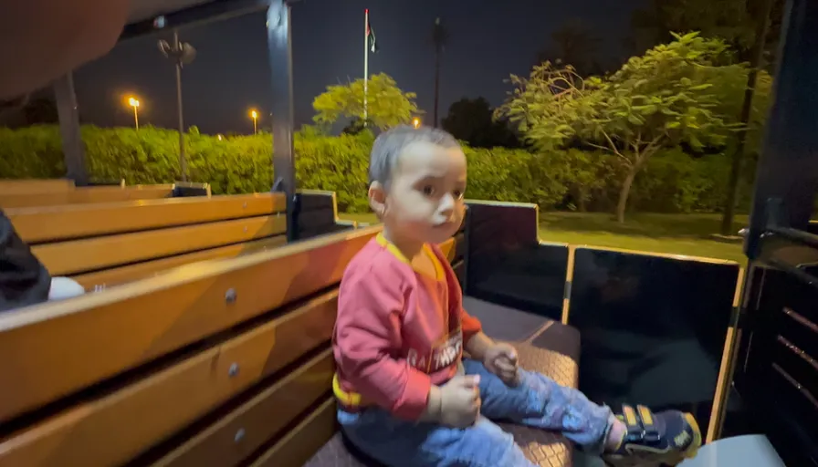 a little girl sitting on a bench at night