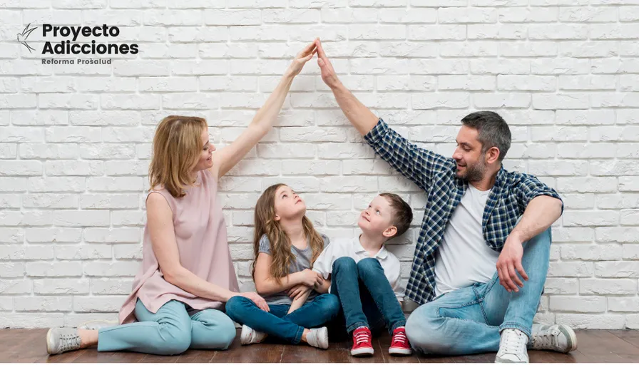 a family sitting on the floor with their arms in the air