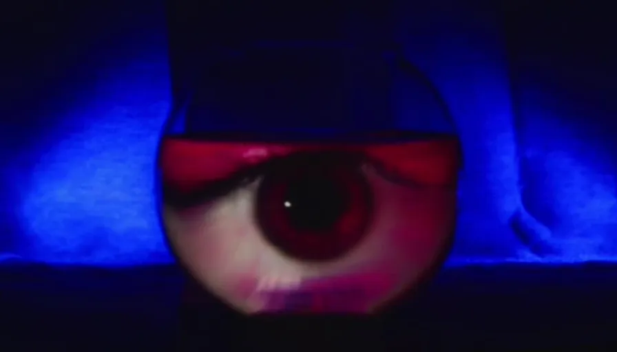 A Glass Eye View of a Person's Eye in the Dark.  a human eye, encapsulated within a glass fishbowl. There it floats, in its spherical confinement, blinking occasionally, creating a mesmerizing sight