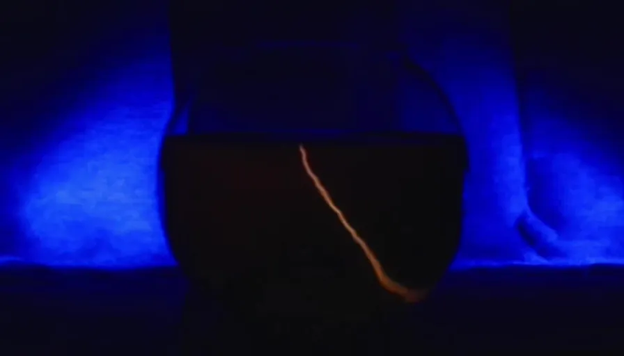 Blue automotive lighting, entertainment, tints and shades, human leg, darkness, encapsulated within a glass fishbowl. The centered object is electric sparks.  tints and shades, electric blue, knee, magenta, darkness, event, electric sparks , encapsulated within a glass fishbowl. centered object