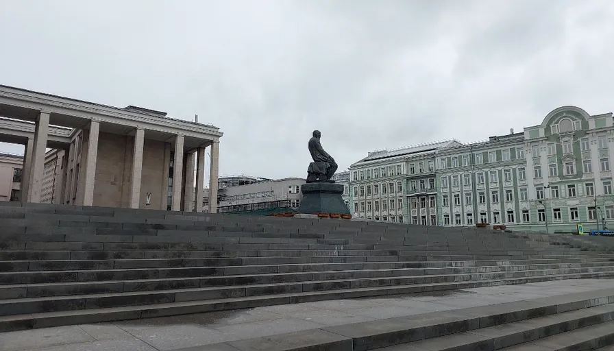 a statue of a man sitting on top of a set of stairs