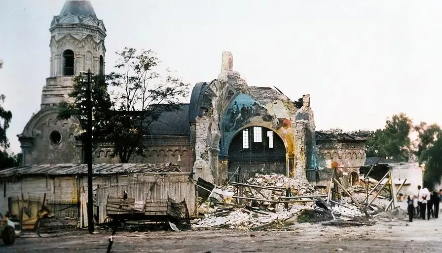 a destroyed building with a clock tower in the background