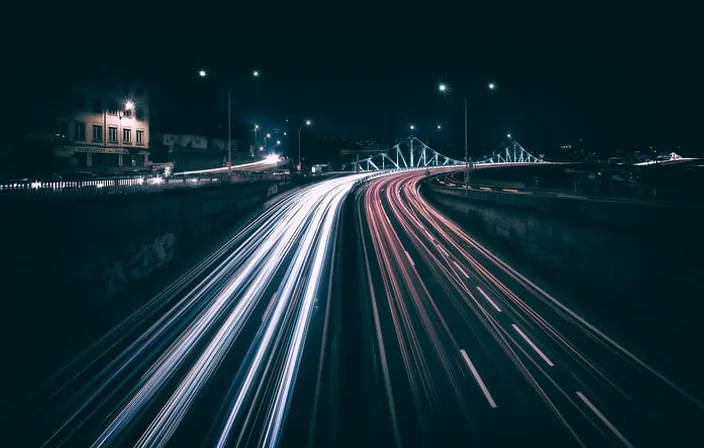 a long exposure photo of a highway at night