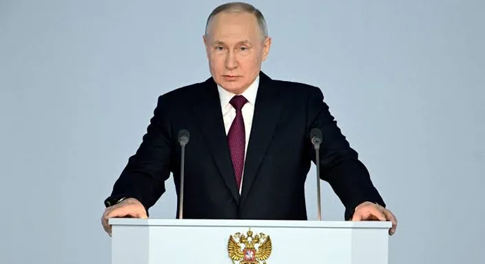 a man in a suit and tie standing at a podium