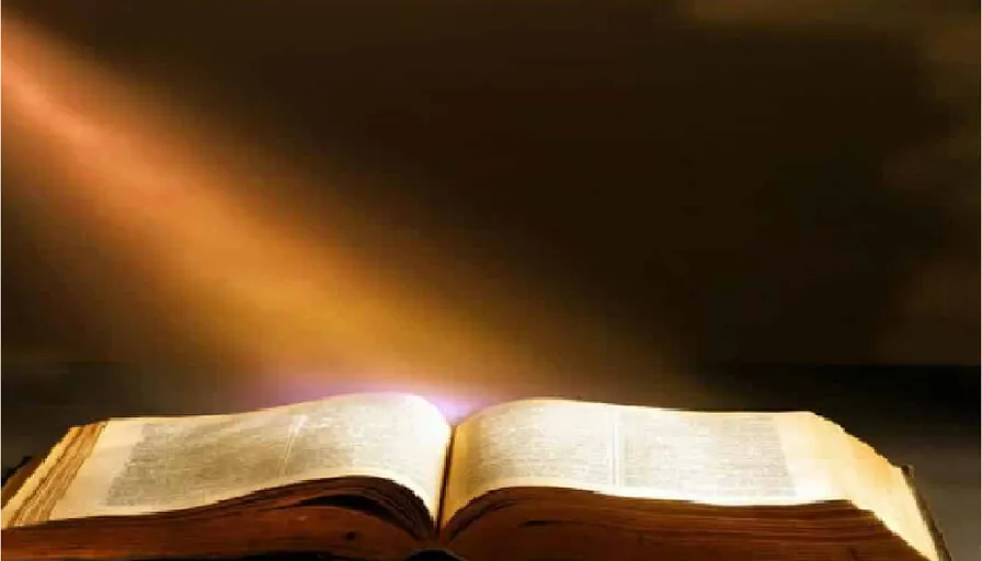 an open book with a light coming out of it