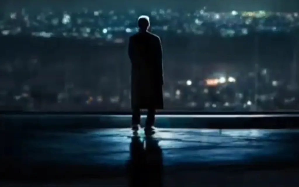 a man standing in the dark looking out at the city