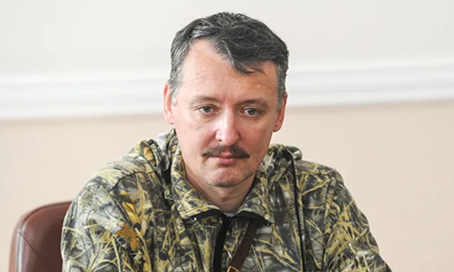 a man with a mustache sitting at a table