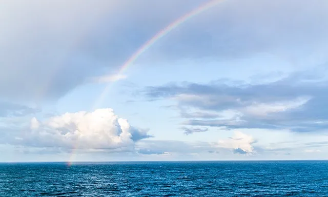 a rainbow in the sky over a body of water