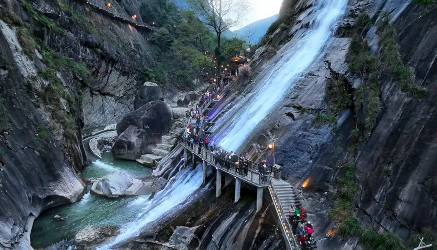 a group of people standing on a bridge over a waterfall