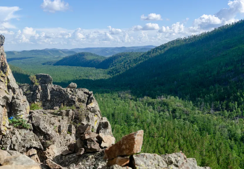 a rocky outcropping with a valley in the distance