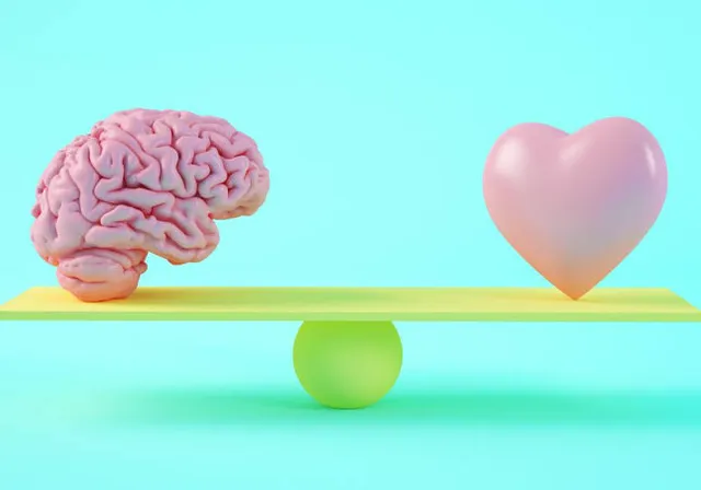 a heart and a brain sitting on a scale