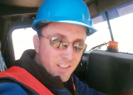 a man wearing a blue hard hat and sunglasses