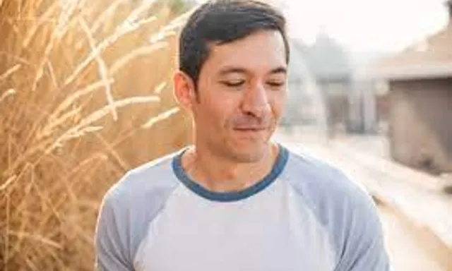 a man standing in front of a tall grass field