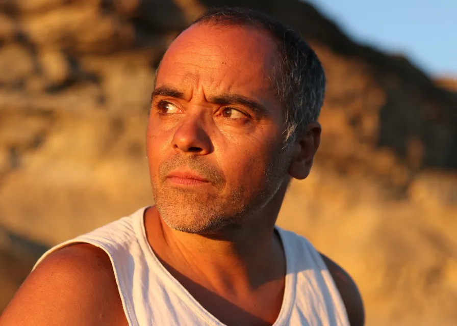 a man in a tank top looking off into the distance
