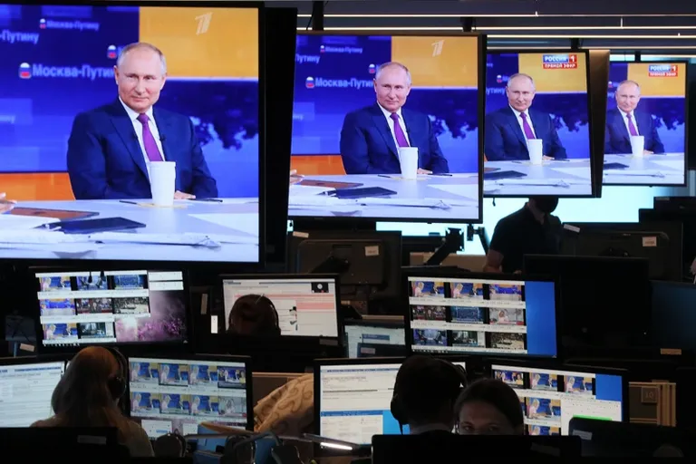 a group of people sitting in front of monitors