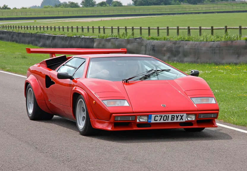 a red sports car driving down a road