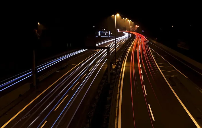 a long exposure photo of a highway at night