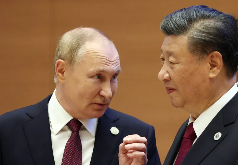 two men standing next to each other in suits